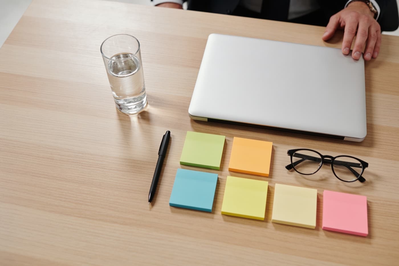 Besprechungstisch von oben mit Marketing-Report, Laptop und sortierten Notizzetteln