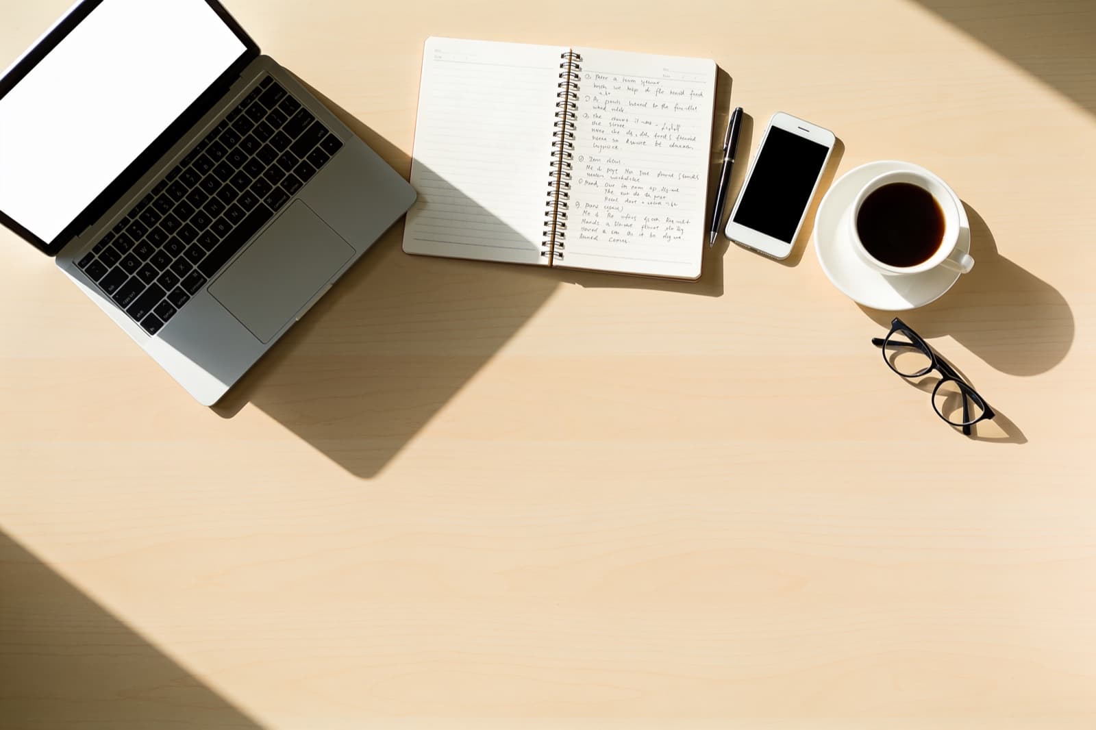 Aufgeräumter Schreibtisch mit Notizbuch, Laptop und Kaffee als Sinnbild für planbare, systematische Akquise statt Zufall